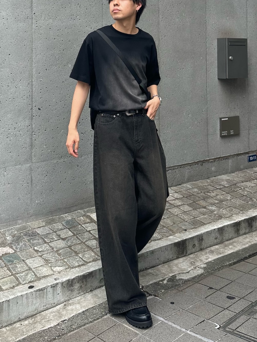 ブラック系のTシャツ/カットソー、ブラック系のショルダーバッグ、ブラック系のデニムパンツを着用したメンズの夏コーディネートの4枚目の写真