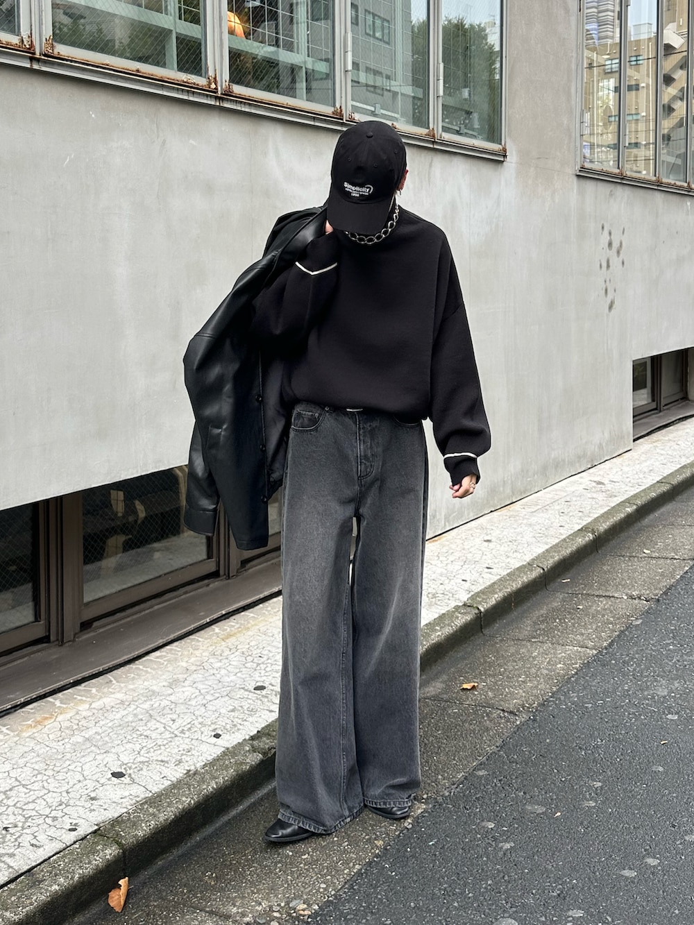 ブラック系のニット/セーター、ブラック系のデニムパンツを着用したメンズの秋コーディネートの2枚目の写真