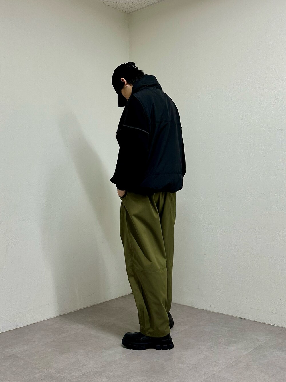 ブラック系のベスト、グリーン系のその他パンツ、ブラック系のスウェットを着用したメンズの春コーディネートの2枚目の写真