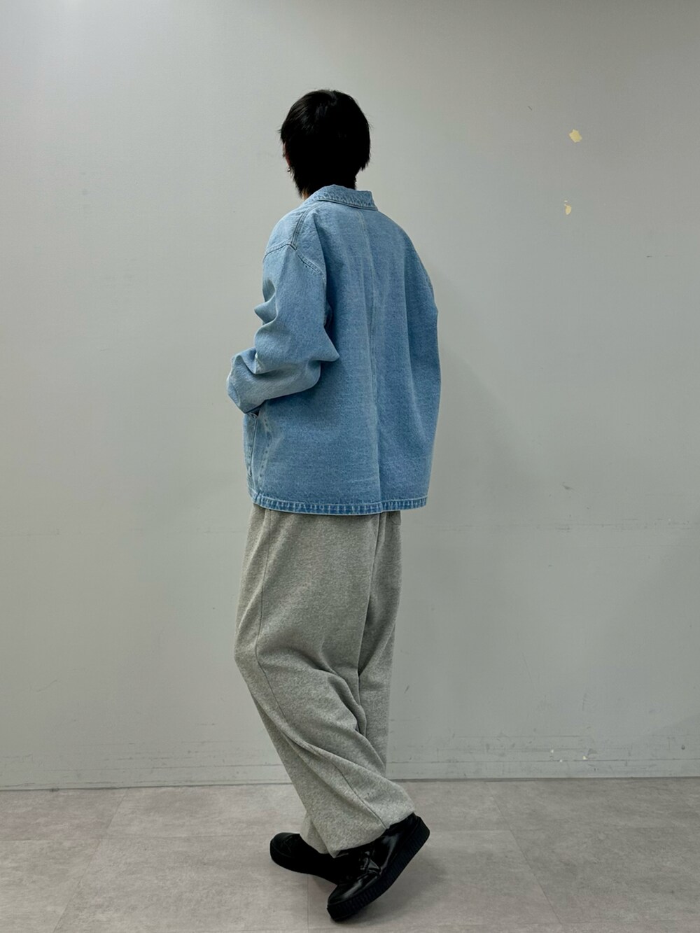 ブルー系のデニムジャケット、グレー系のスウェットパンツ、ブラック系のスニーカーを着用したメンズの冬コーディネートの5枚目の写真