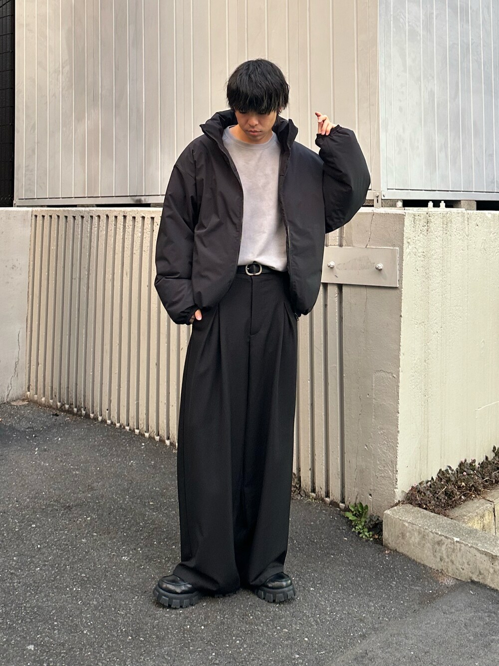 ブラック系のダウンジャケット/コート、ホワイト系のTシャツ/カットソー、ブラック系のスラックスを着用したメンズの冬コーディネートの2枚目の写真