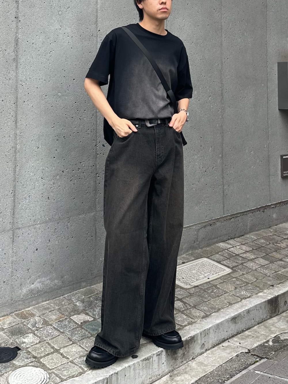 ブラック系のTシャツ/カットソー、ブラック系のショルダーバッグ、ブラック系のデニムパンツを着用したメンズの夏コーディネートの2枚目の写真