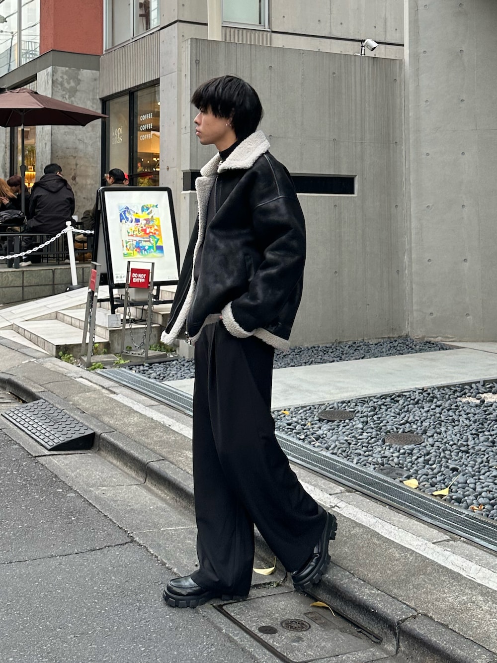 ブラック系のムートンコート、ブラック系のニット/セーターを着用したメンズの冬コーディネートの3枚目の写真