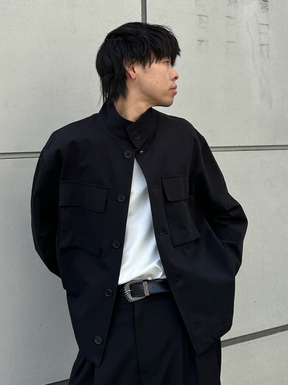 ブラック系のその他アウター、ブラック系のスラックス、ブラック系のベルトを着用したメンズの冬コーディネートの5枚目の写真