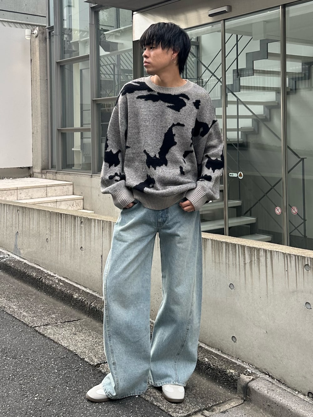 グレー系のニット/セーター、ブルー系のデニムパンツ、ホワイト系のスニーカーを着用したメンズの秋コーディネートの4枚目の写真