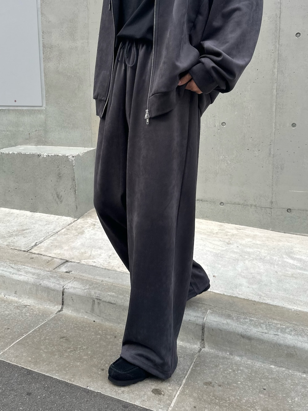 グレー系のパーカー、グレー系のスウェットパンツ、シルバー系のネックレスを着用したメンズの秋コーディネートの5枚目の写真