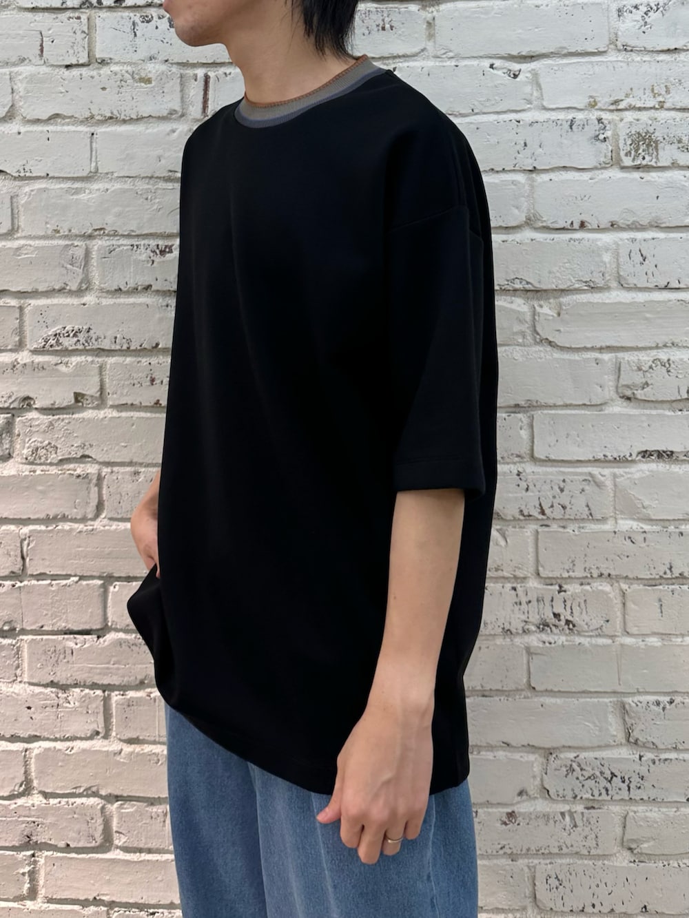 ブラック系のTシャツ/カットソー、ブルー系のデニムパンツを着用したメンズの春コーディネートの3枚目の写真