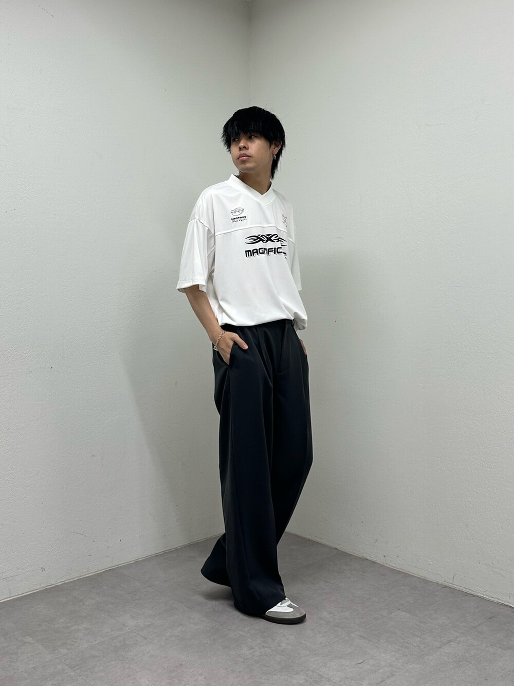 ホワイト系のTシャツ/カットソー、ブラック系のスラックスを着用したメンズの春コーディネートの5枚目の写真