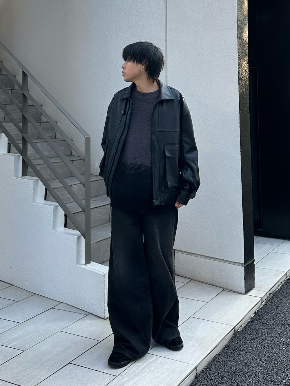 ブラック系のブルゾン、グレー系のニット/セーター、ブラック系のデニムパンツを着用したメンズの秋コーディネートの2枚目の写真
