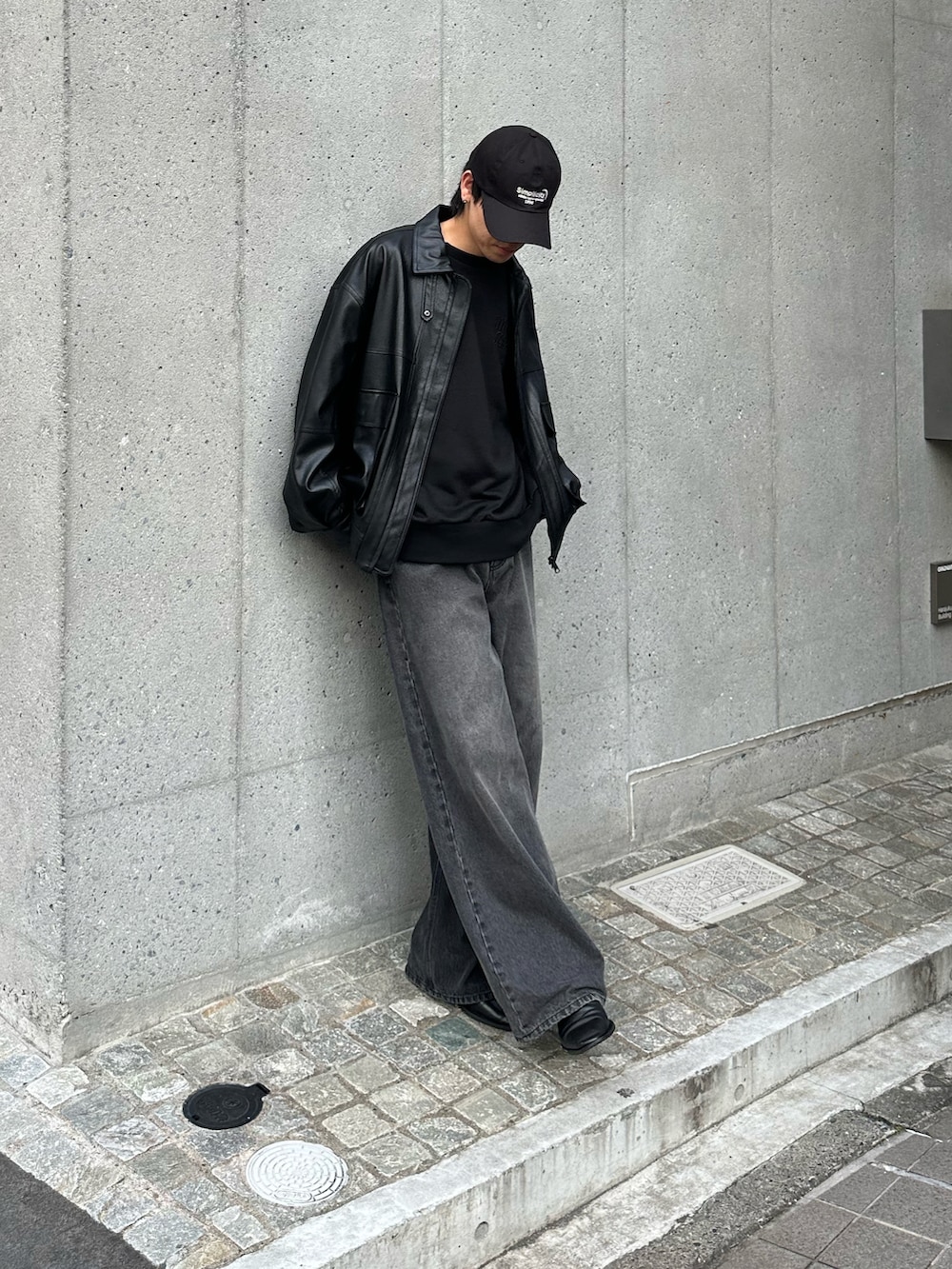 ブラック系のTシャツ/カットソー、ブラック系のデニムパンツ、ブラック系のブルゾンを着用したメンズの秋コーディネートの2枚目の写真