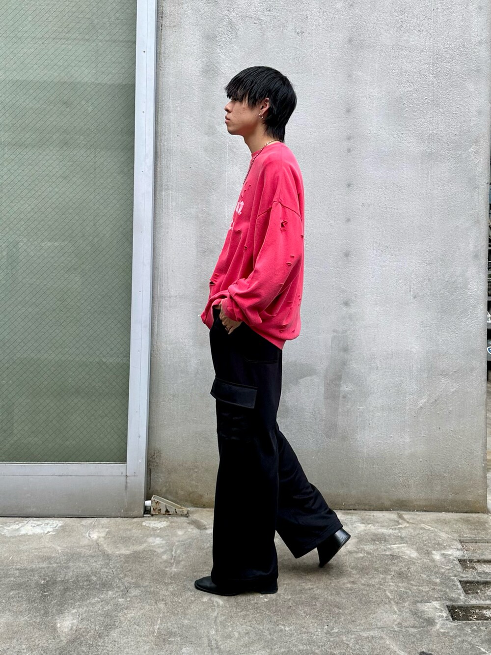 レッド系のスウェット、ブラック系のカーゴパンツを着用したメンズの秋コーディネートの2枚目の写真