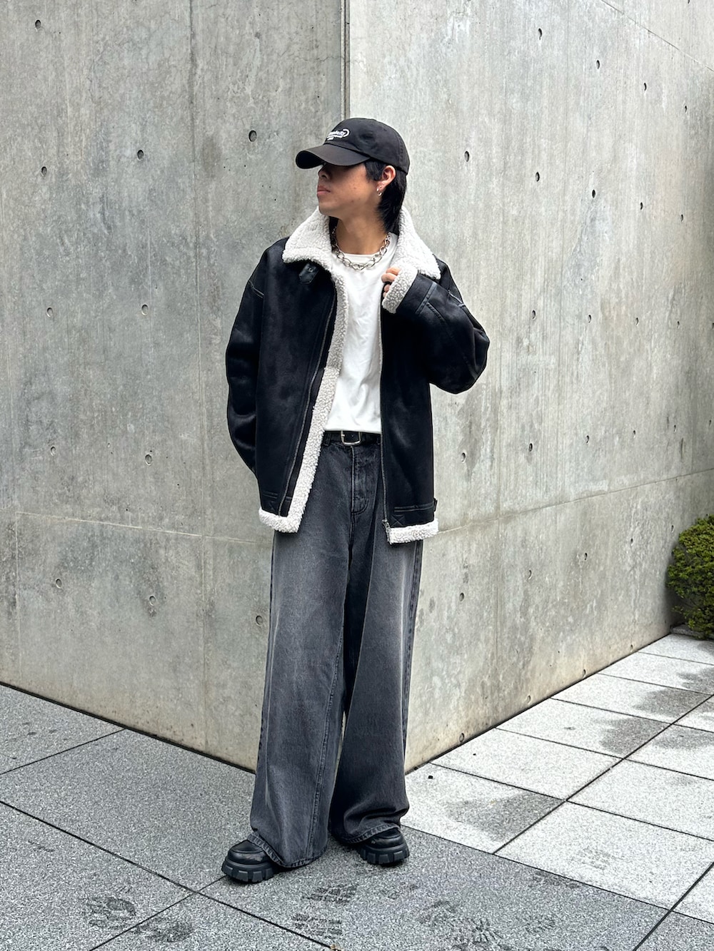 ブラック系のデニムパンツ、ブラック系のムートンコート、ブラック系のキャップを着用したメンズの秋コーディネートの3枚目の写真