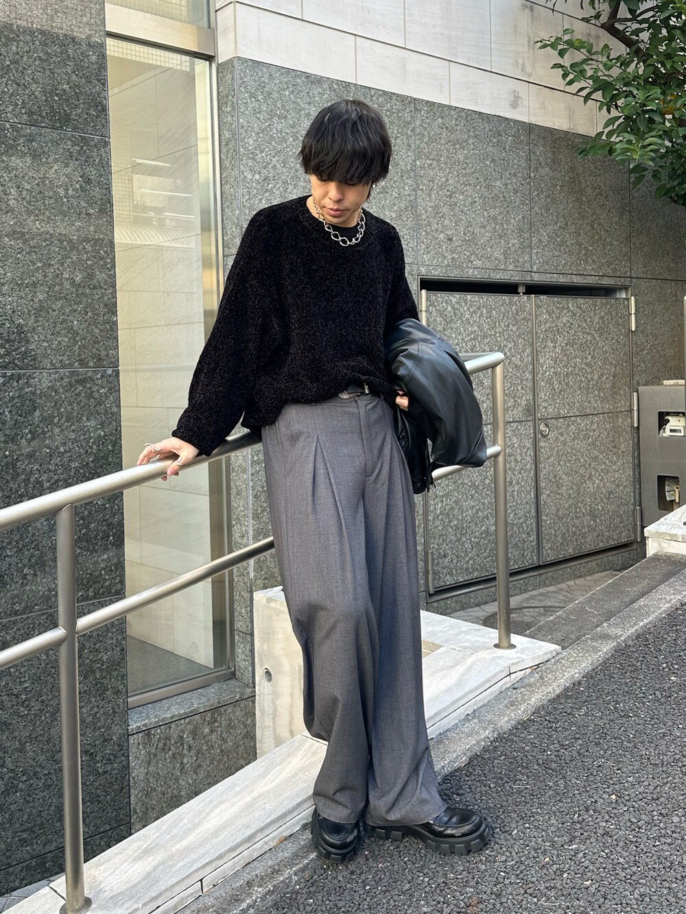 ブラック系のブルゾン、ブラック系のTシャツ/カットソー、グレー系のスラックスを着用したメンズの冬コーディネートの5枚目の写真