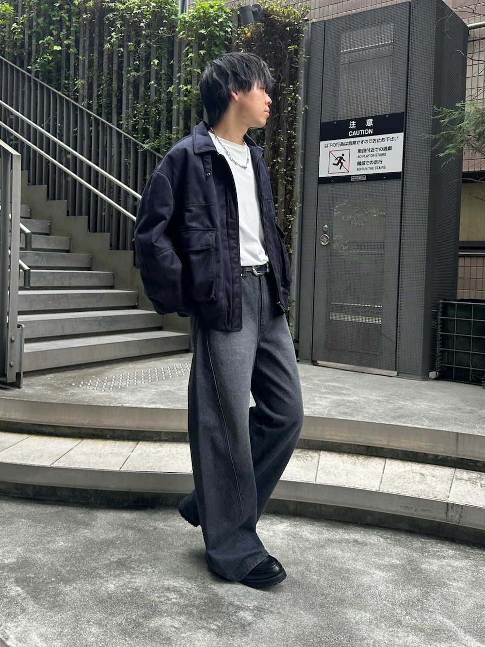 ブラック系のブルゾン、ブラック系のデニムパンツ、ブラック系のドレスシューズを着用したメンズの秋コーディネートの4枚目の写真