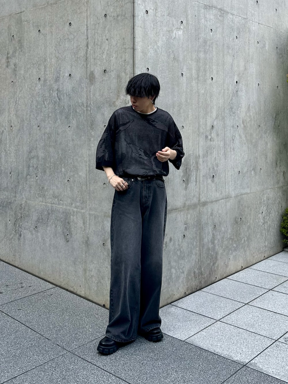 ブラック系のニット/セーター、ホワイト系のTシャツ/カットソー、ブラック系のデニムパンツを着用したメンズの夏コーディネートの3枚目の写真