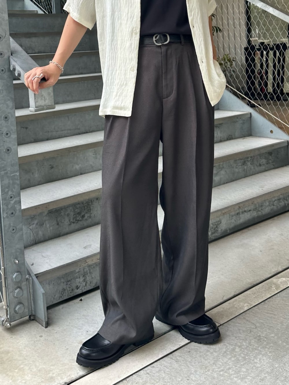 グレー系のスラックス、ホワイト系のシャツ/ブラウス、ブラック系のベルトを着用したメンズの夏コーディネートの2枚目の写真