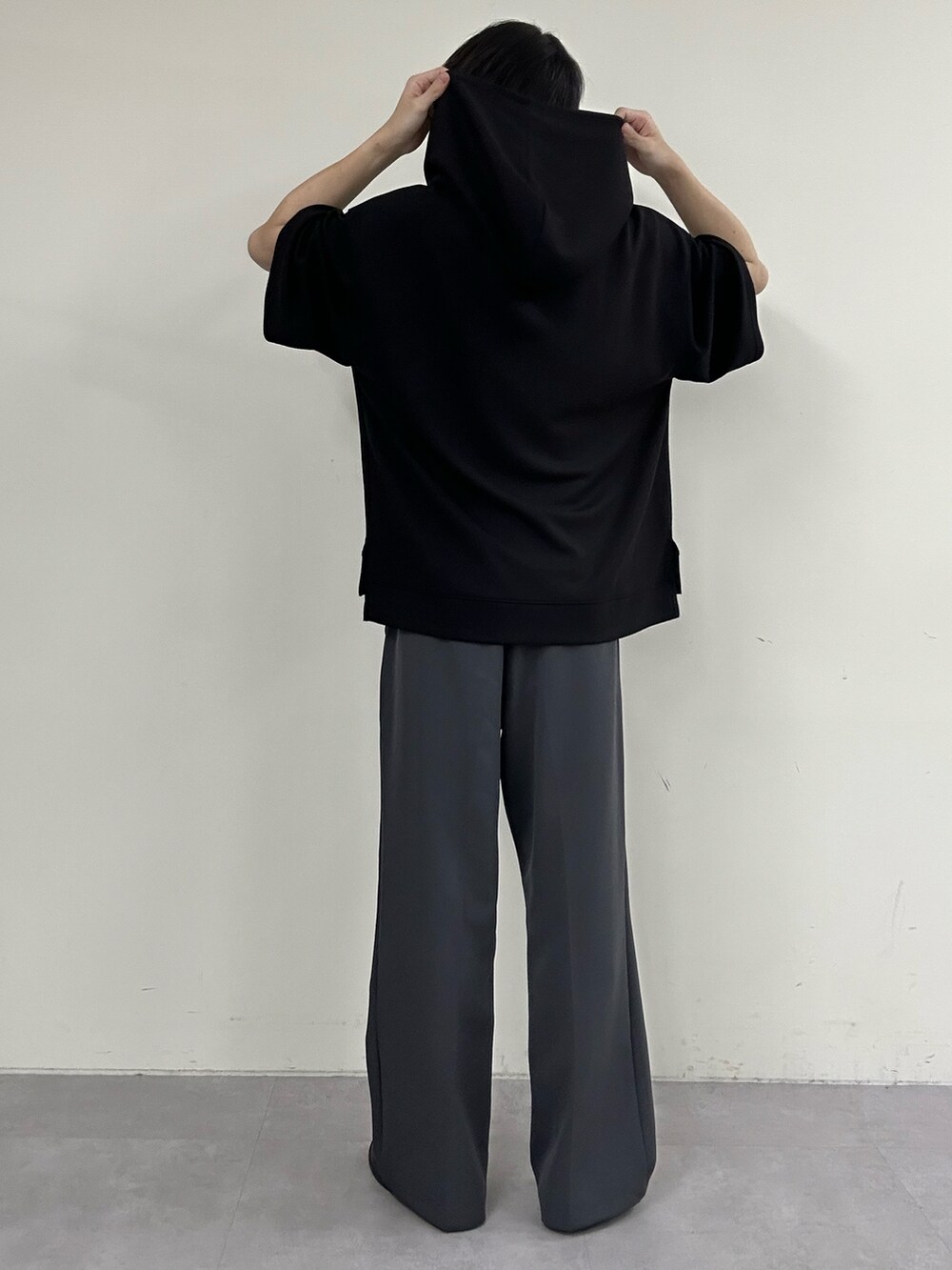 グレー系のスラックス、ブラック系のパーカーを着用したメンズの春コーディネートの3枚目の写真