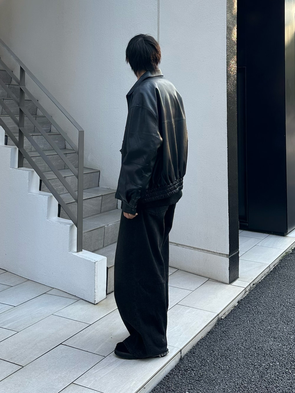 ブラック系のブルゾン、グレー系のニット/セーター、ブラック系のデニムパンツを着用したメンズの秋コーディネートの3枚目の写真