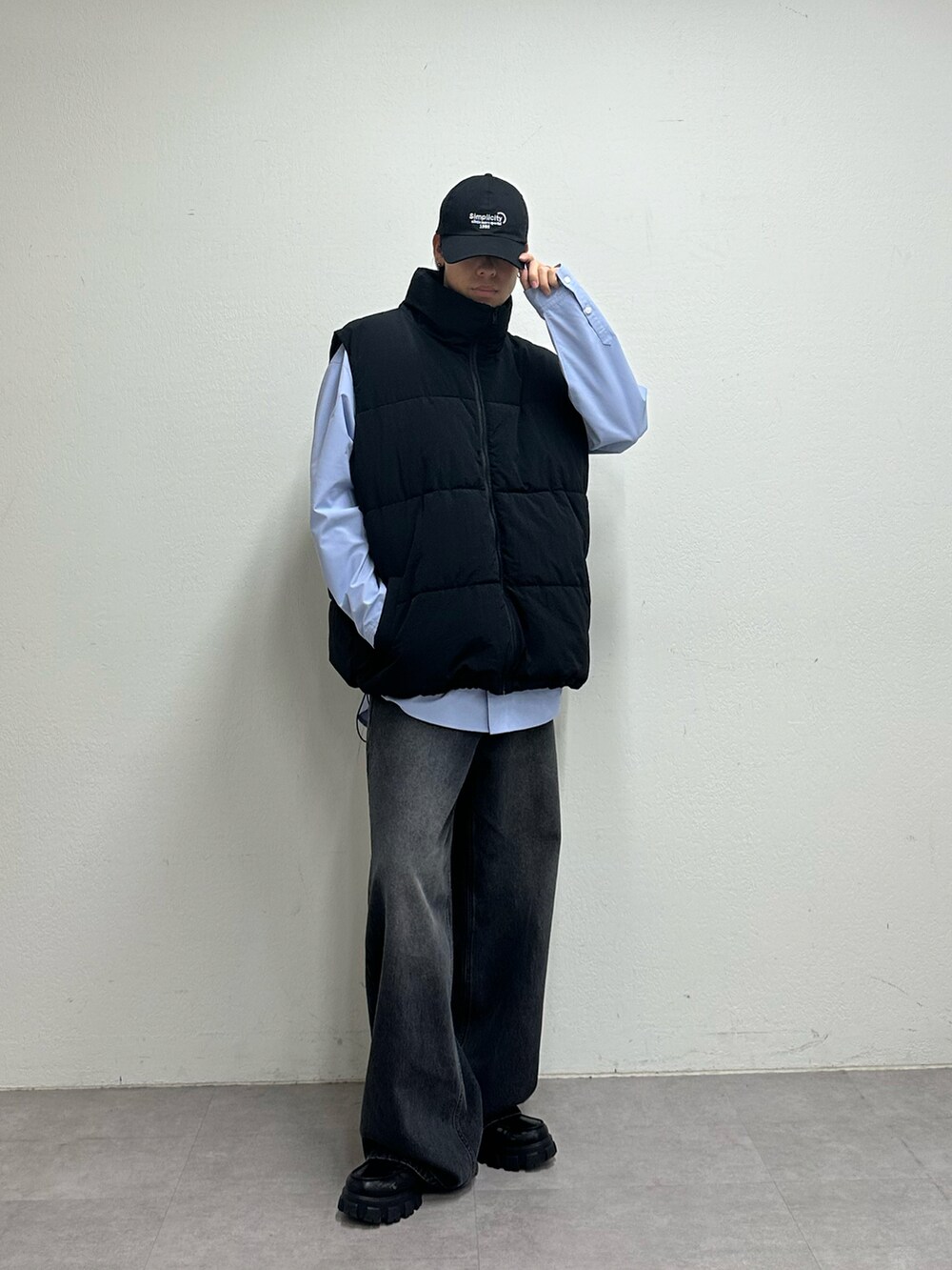 ブラック系のダウンベスト、ブラック系のデニムパンツ、ブルー系のキャップを着用したメンズの夏コーディネートの5枚目の写真