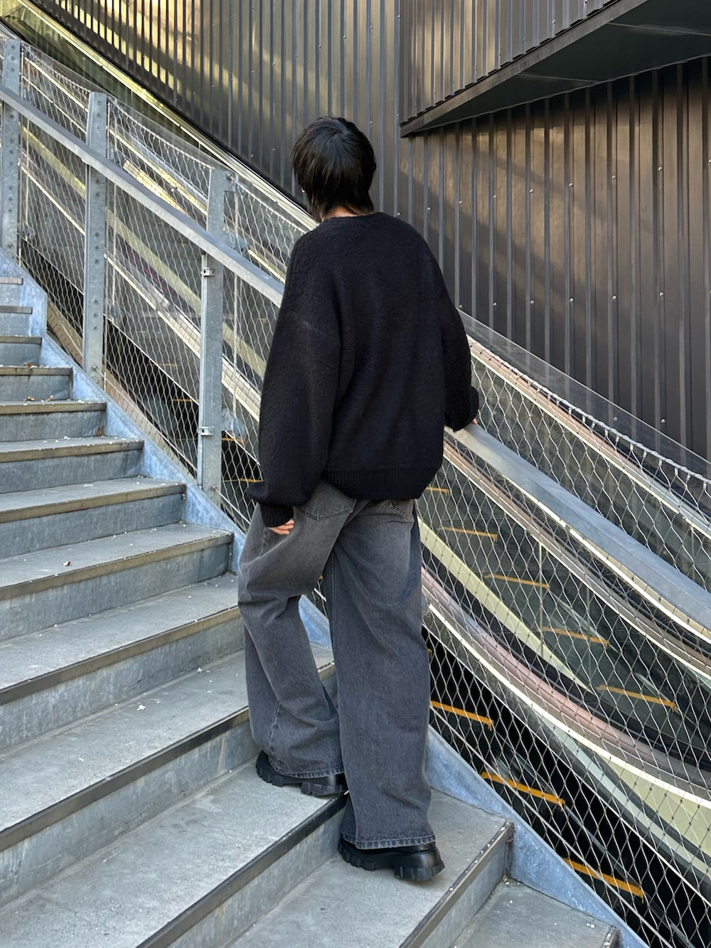 ブラック系のニット/セーター、ブラック系のデニムパンツを着用したメンズの冬コーディネートの3枚目の写真