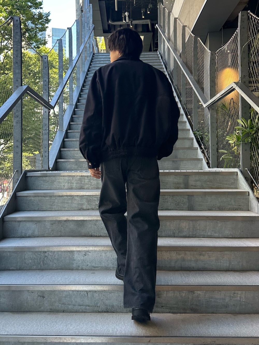 ブラック系のブルゾン、ブラック系のデニムパンツ、ブラック系のベルトを着用したメンズの夏コーディネートの3枚目の写真