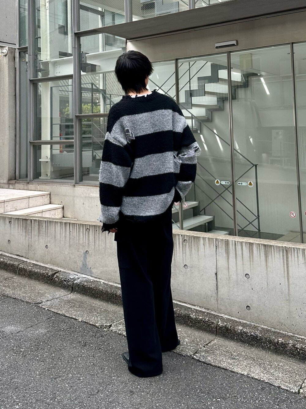 ブラック系のニット/セーター、ブラック系のカーゴパンツを着用したメンズの秋コーディネートの2枚目の写真