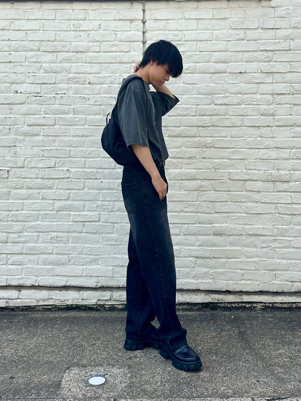 グレー系のTシャツ/カットソー、ブラック系のデニムパンツ、ブラック系のショルダーバッグを着用したメンズの春コーディネートの2枚目の写真