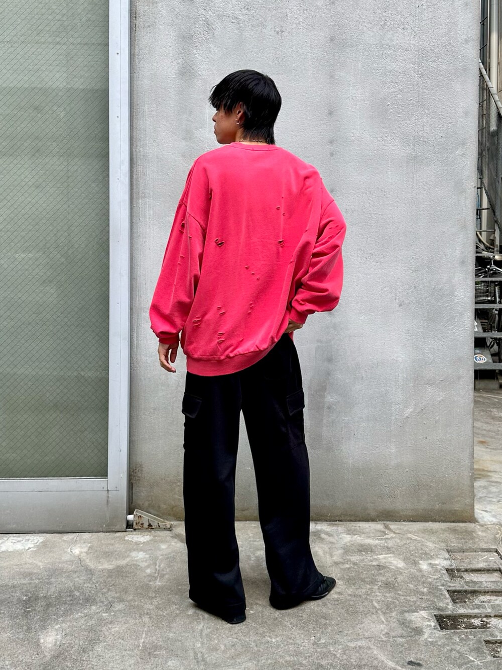 レッド系のスウェット、ブラック系のカーゴパンツを着用したメンズの秋コーディネートの3枚目の写真