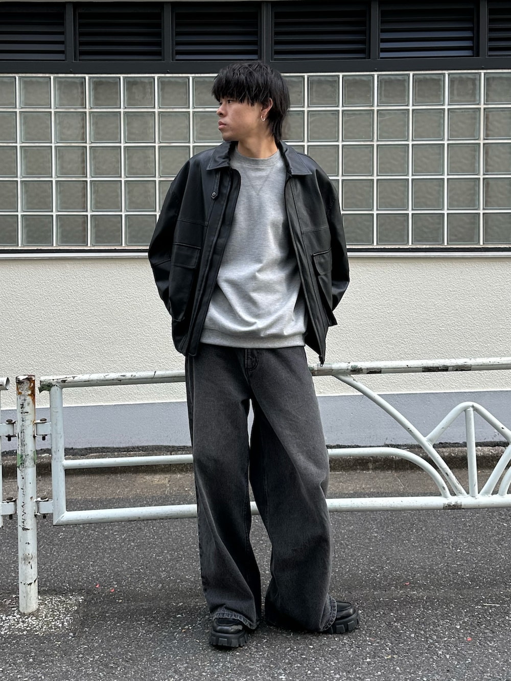 ブラック系のデニムパンツ、ブラック系のブルゾン、グレー系のTシャツ/カットソーを着用したメンズの冬コーディネートの5枚目の写真