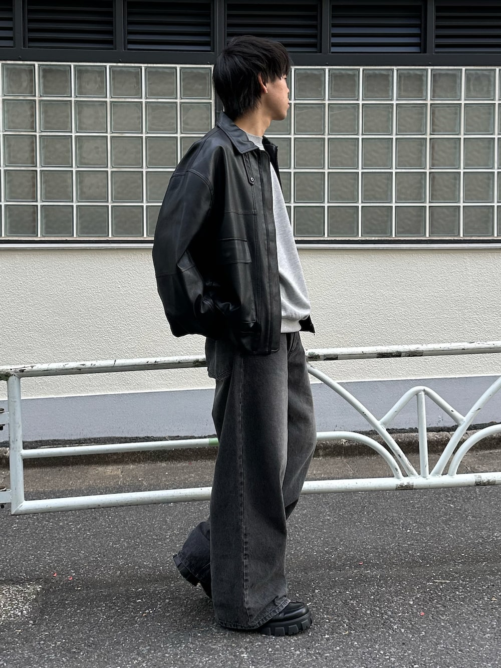 ブラック系のデニムパンツ、ブラック系のブルゾン、グレー系のTシャツ/カットソーを着用したメンズの冬コーディネートの4枚目の写真