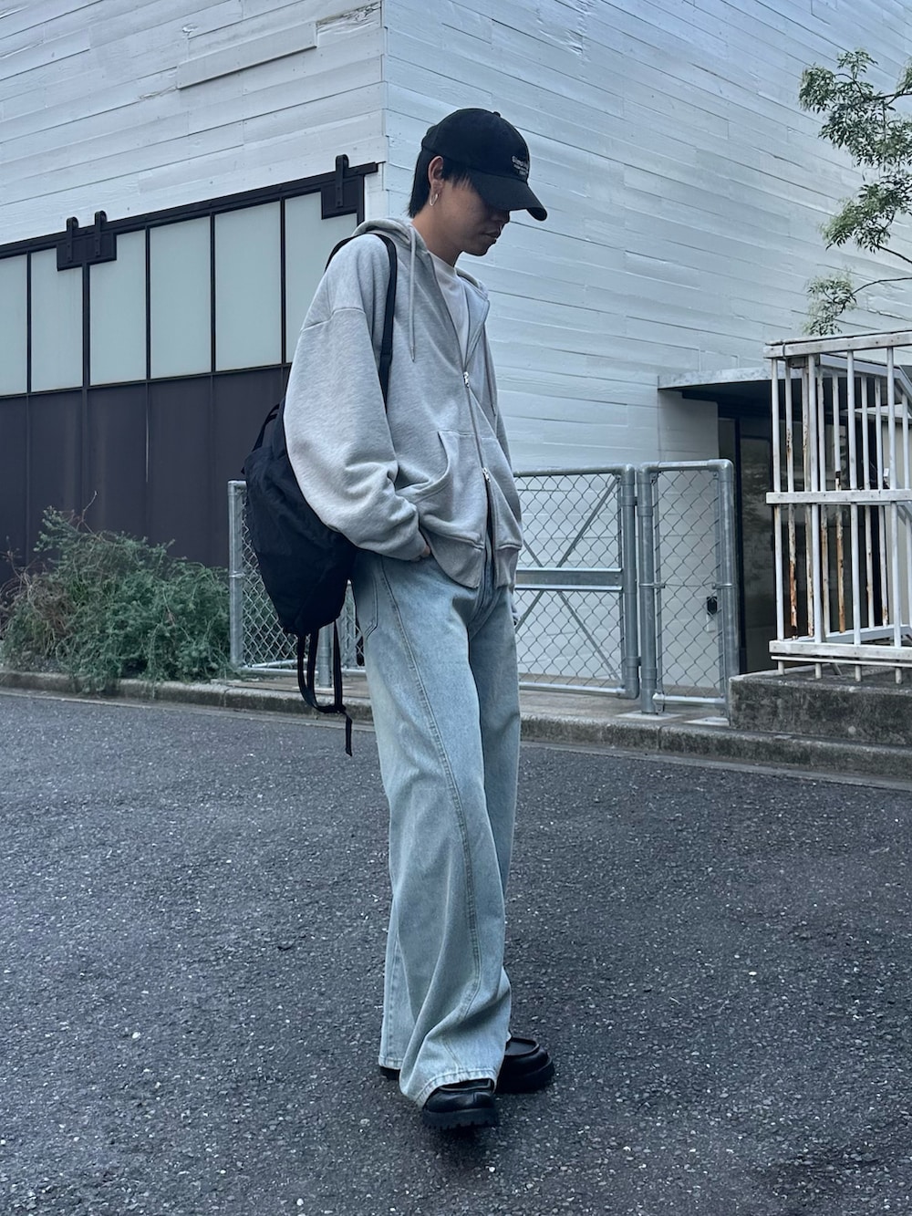 ブラック系のバックパック/リュック、グレー系のパーカー、ブルー系のデニムパンツを着用したメンズの秋コーディネートの5枚目の写真