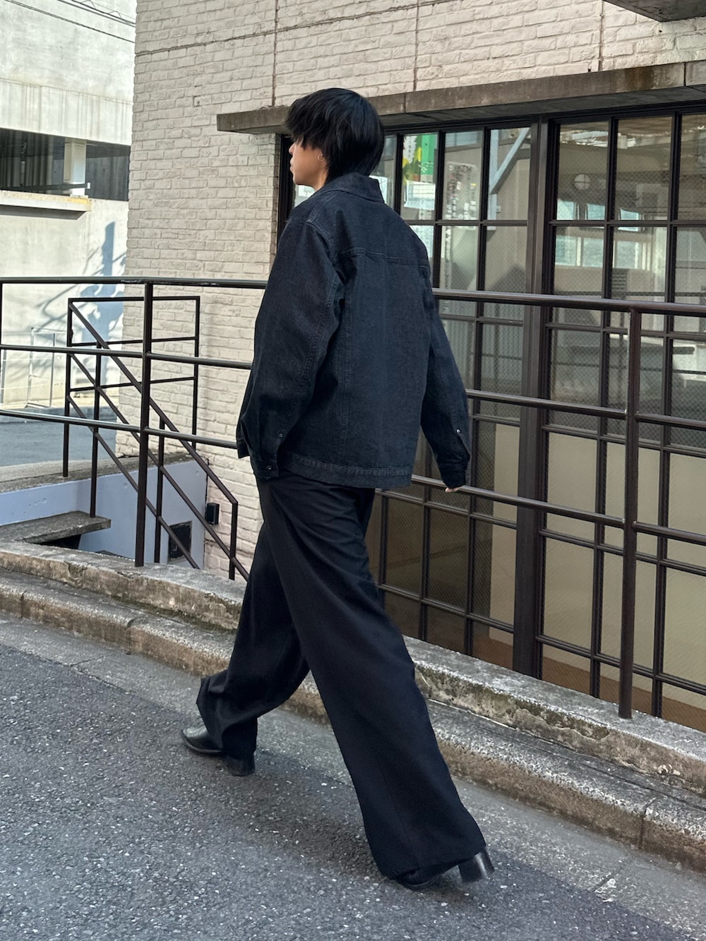 ブラック系のTシャツ/カットソー、ブラック系のスラックス、ブラック系のデニムジャケットを着用したメンズの春コーディネートの2枚目の写真