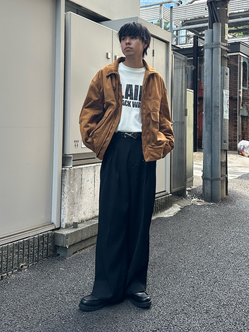 イエロー系のブルゾン、ブラック系のスラックス、ホワイト系のTシャツ/カットソーを着用したメンズの秋コーディネートの5枚目の写真