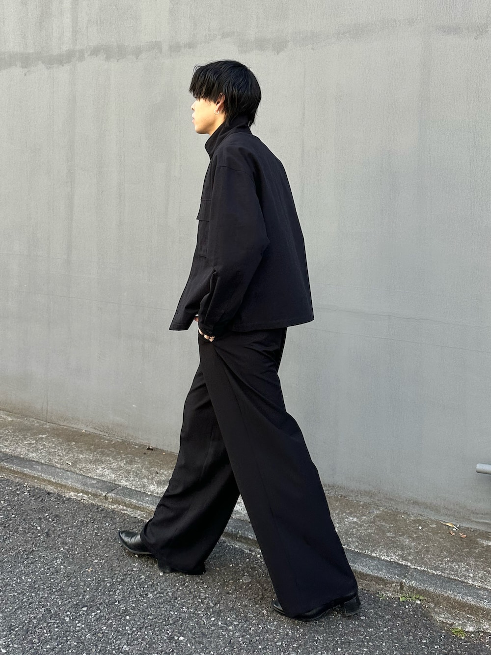 ブラック系のその他アウター、ブラック系のスラックス、ブラック系のベルトを着用したメンズの冬コーディネートの2枚目の写真