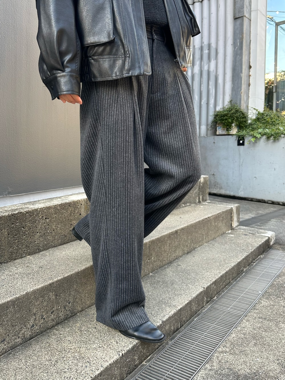 ブラック系のニット/セーター、ブラック系のブルゾン、ブラック系のスラックスを着用したメンズの冬コーディネートの4枚目の写真