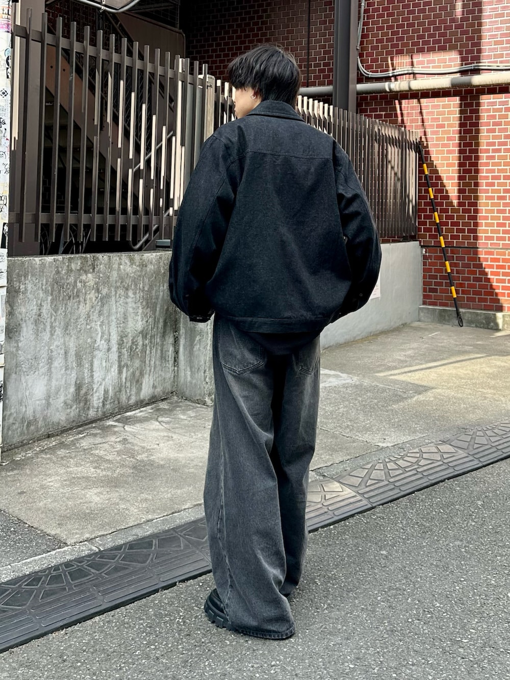 ブラック系のデニムジャケット、ブラック系のTシャツ/カットソー、ブラック系のデニムパンツを着用したメンズの冬コーディネートの3枚目の写真