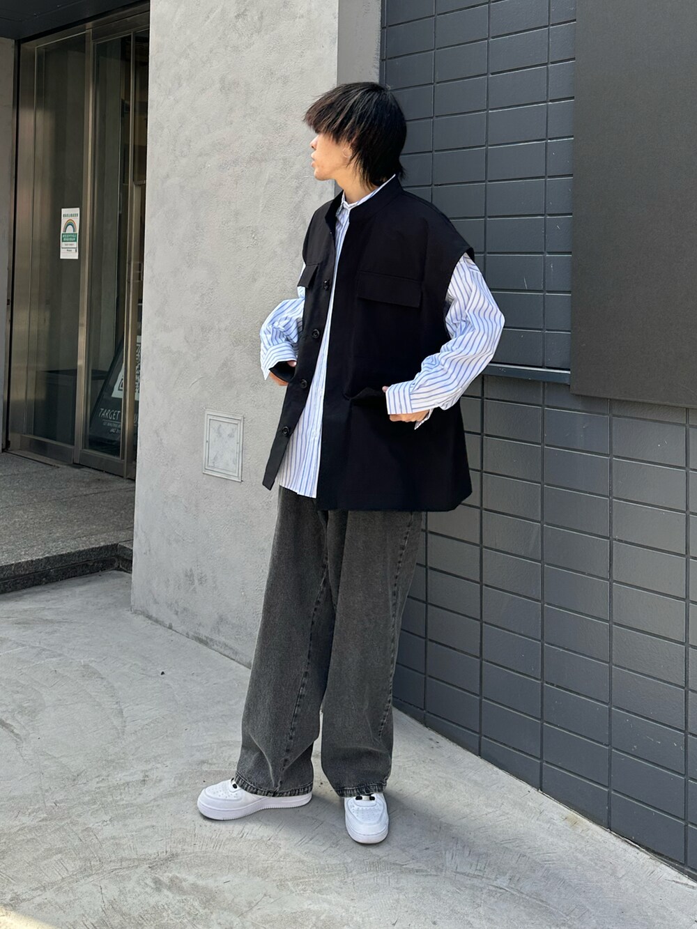 ブラック系のベスト、ホワイト系のシャツ/ブラウス、グレー系のデニムパンツを着用したメンズの春コーディネートの2枚目の写真