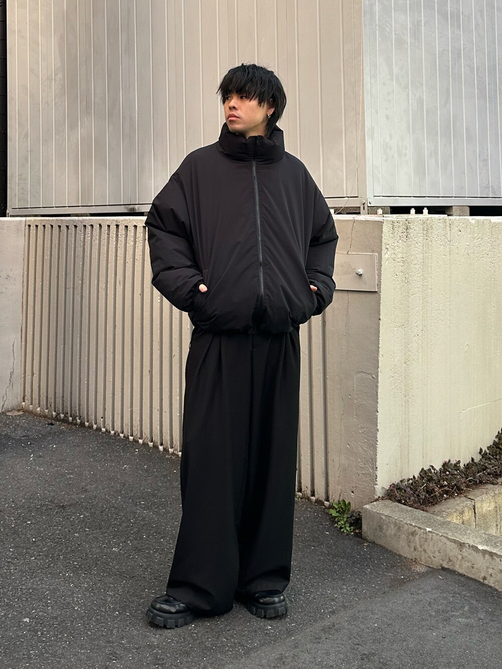 ブラック系のダウンジャケット/コート、ホワイト系のTシャツ/カットソー、ブラック系のスラックスを着用したメンズの冬コーディネートの5枚目の写真