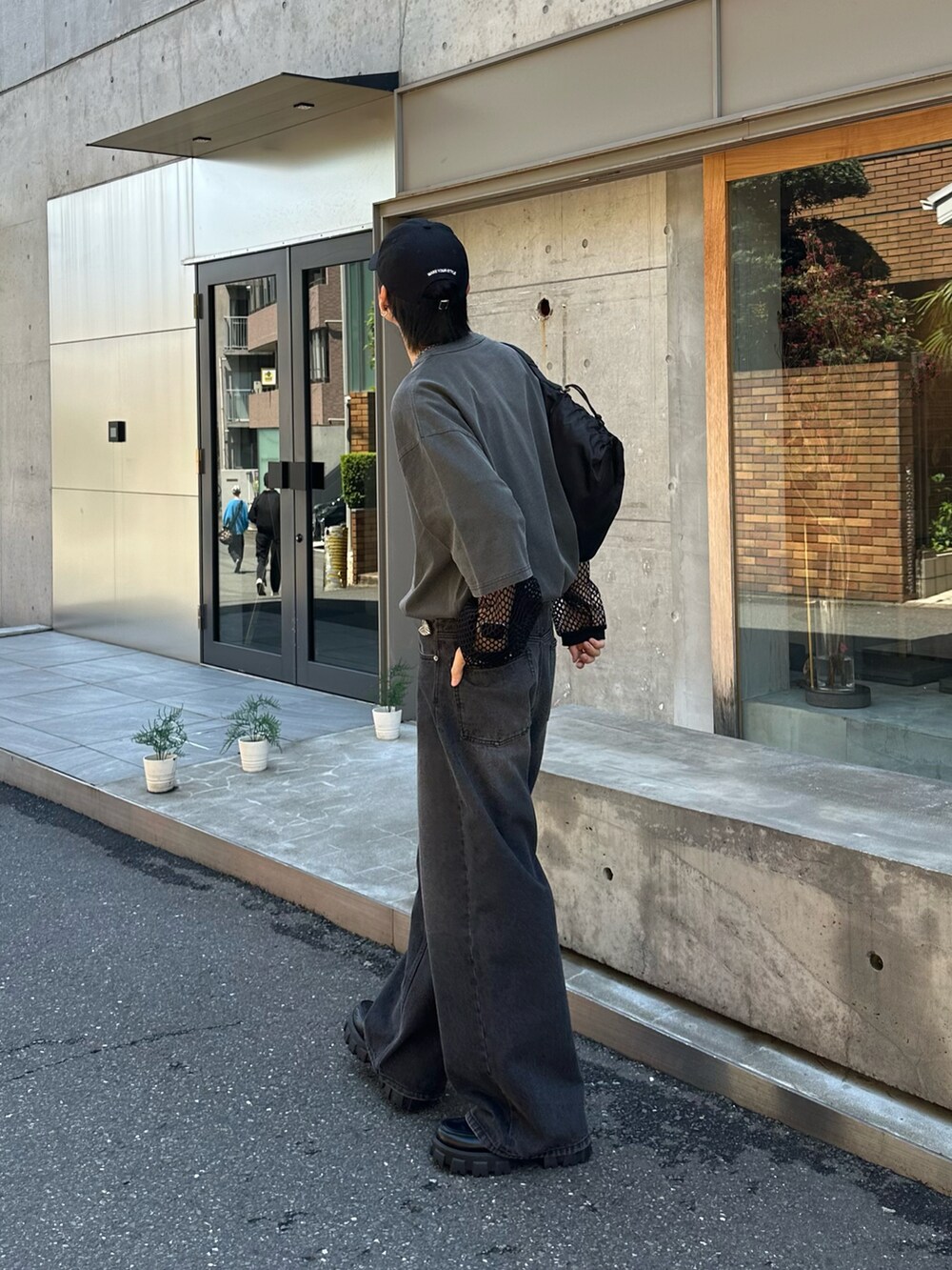 グレー系のTシャツ/カットソー、ブラック系のデニムパンツ、ブラック系のショルダーバッグを着用したメンズの春コーディネートの4枚目の写真