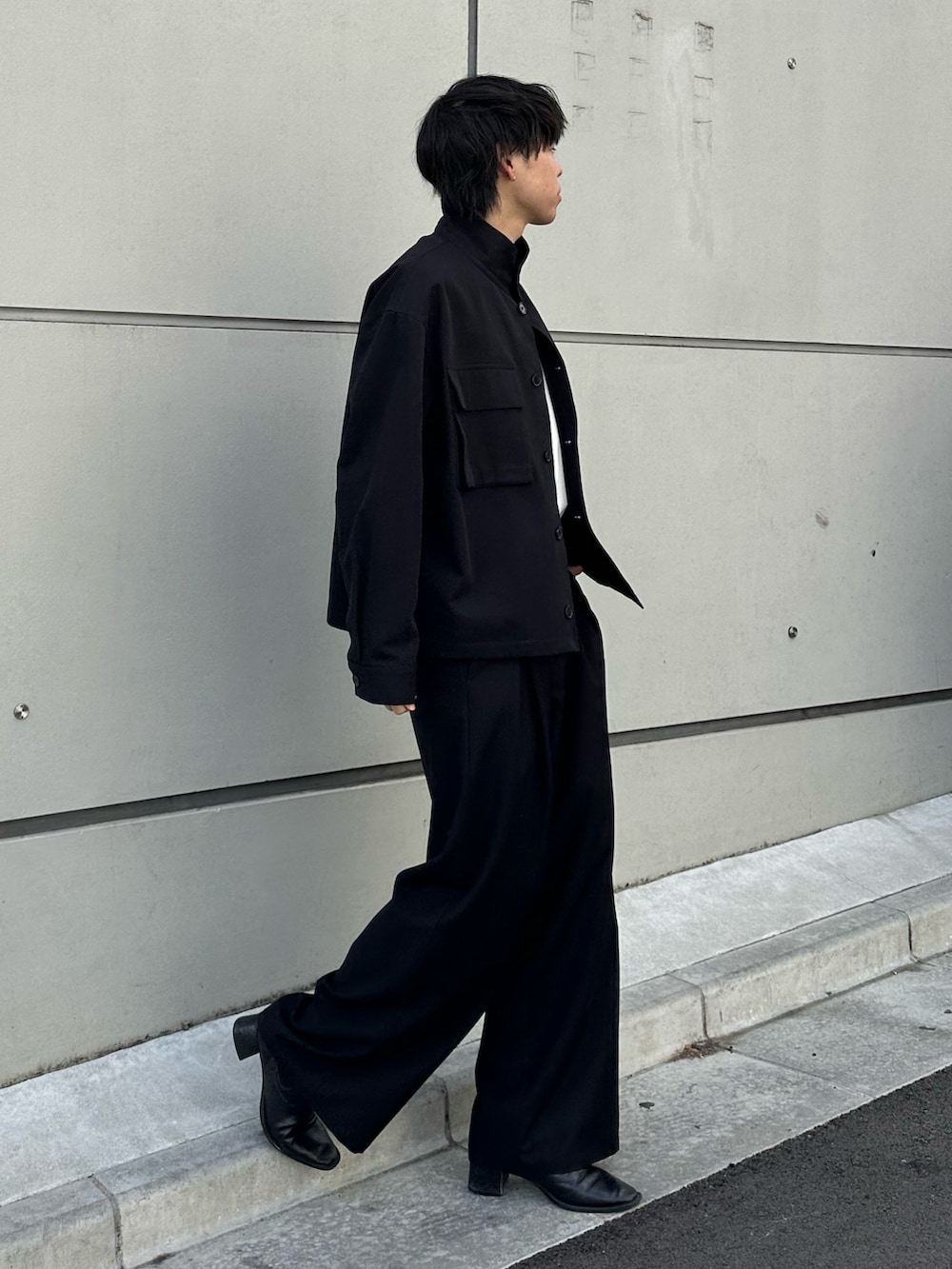 ブラック系のその他アウター、ブラック系のスラックス、ブラック系のベルトを着用したメンズの冬コーディネートの4枚目の写真