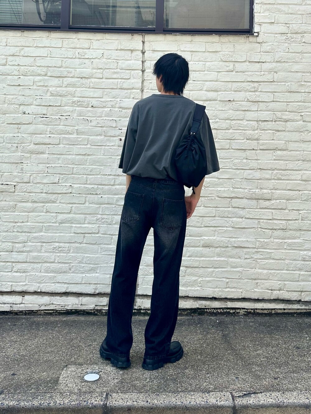 グレー系のTシャツ/カットソー、ブラック系のデニムパンツ、ブラック系のショルダーバッグを着用したメンズの春コーディネートの3枚目の写真