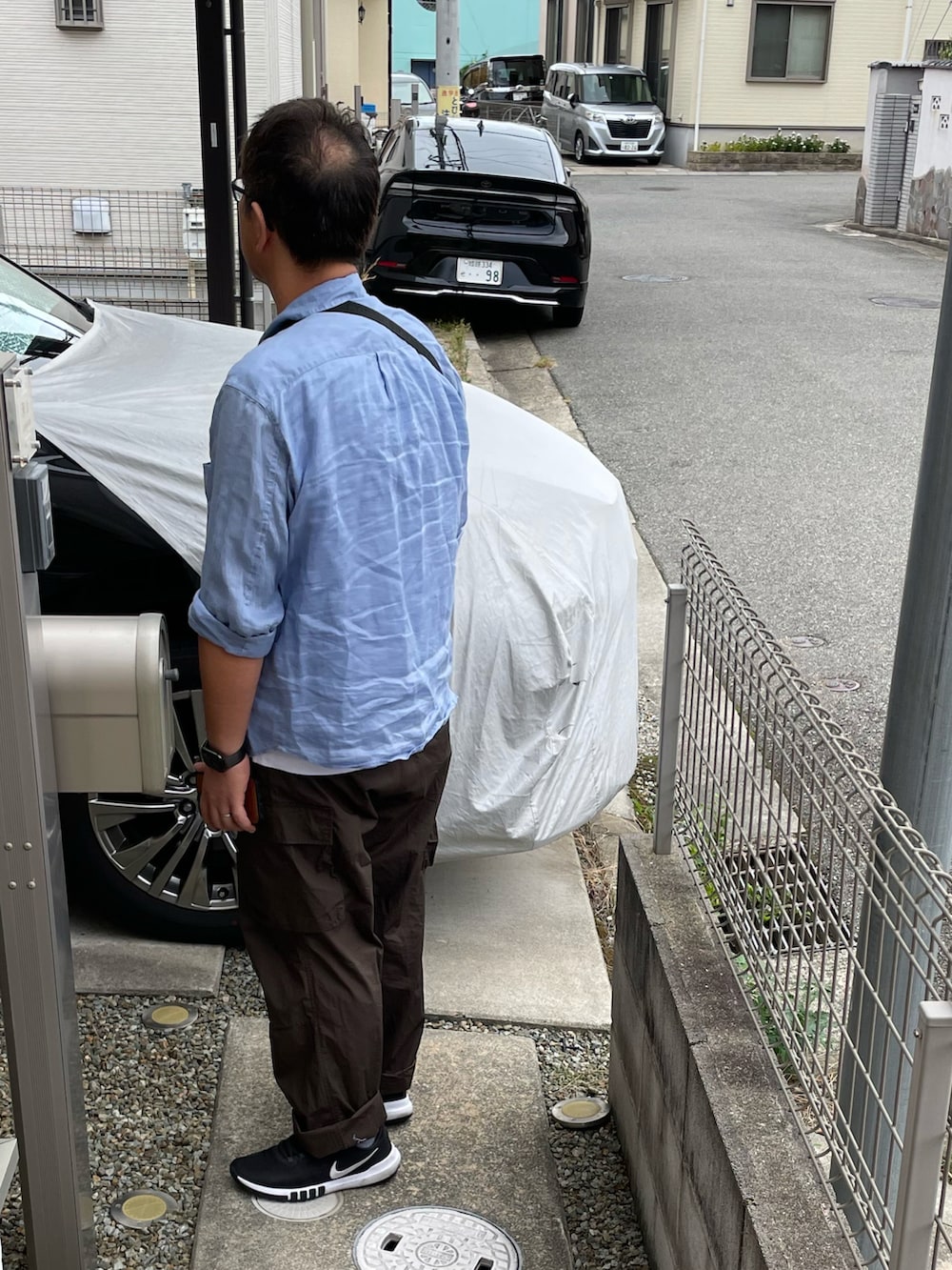 ブルー系のシャツ/ブラウス、ブラウン系のカーゴパンツ、ブラック系のスニーカーを着用したメンズの秋コーディネートの2枚目の写真