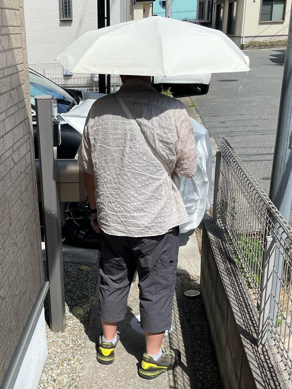 グリーン系のスニーカー、ベージュ系のシャツ/ブラウス、ホワイト系のショルダーバッグを着用したメンズの夏コーディネートの2枚目の写真
