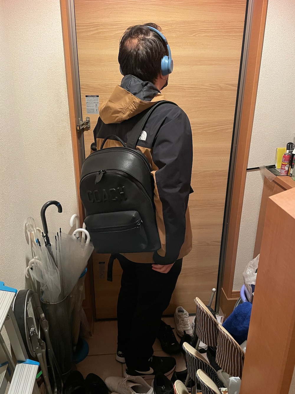 ブラウン系のマウンテンパーカー、ブラック系のスニーカー、ブラック系のバックパック/リュックを着用したメンズの秋コーディネートの2枚目の写真