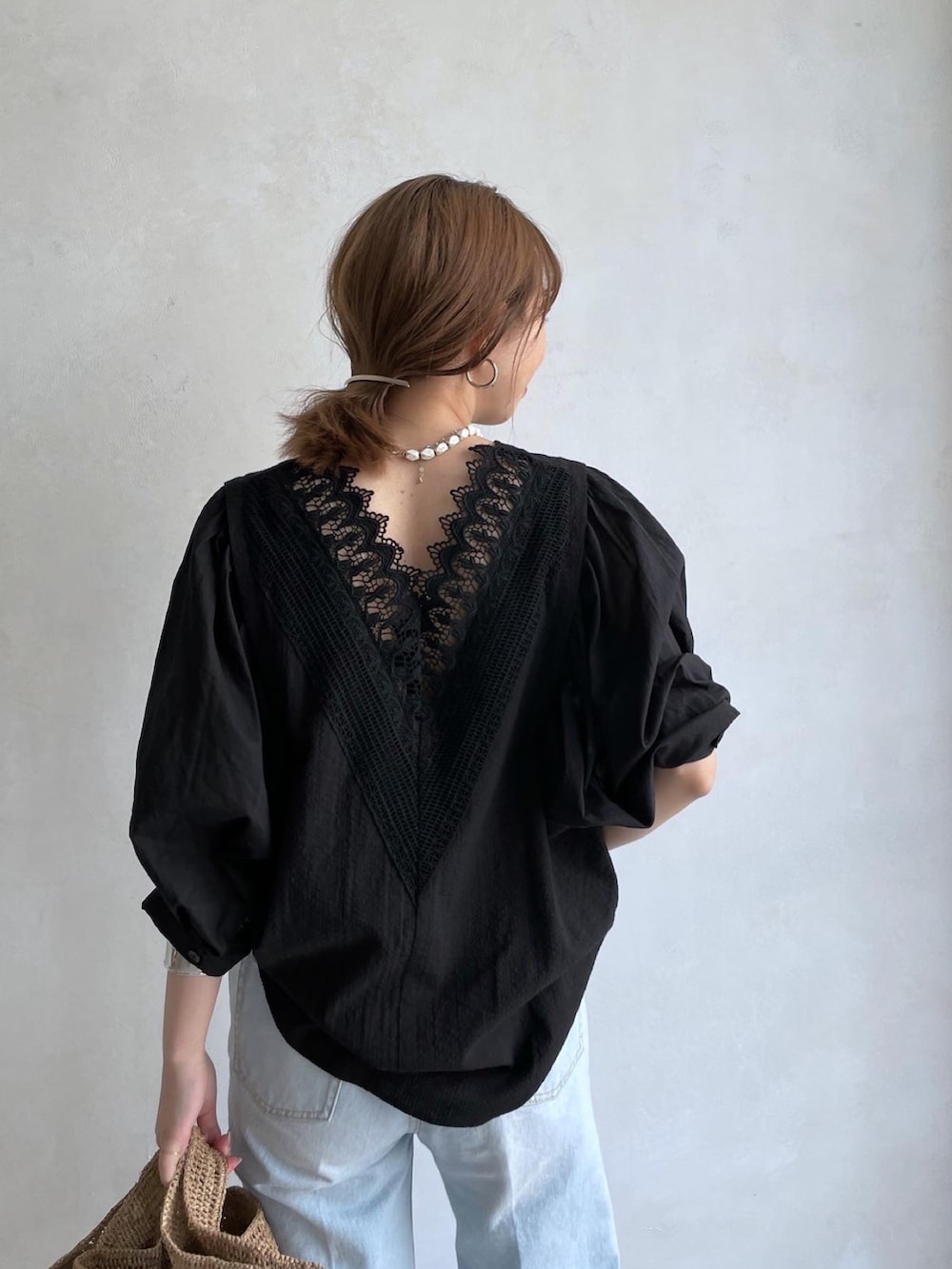 ブラック系のシャツ/ブラウス、ブルー系のデニムパンツ、ブラウン系のかごバッグを着用したレディースの春コーディネートの2枚目の写真