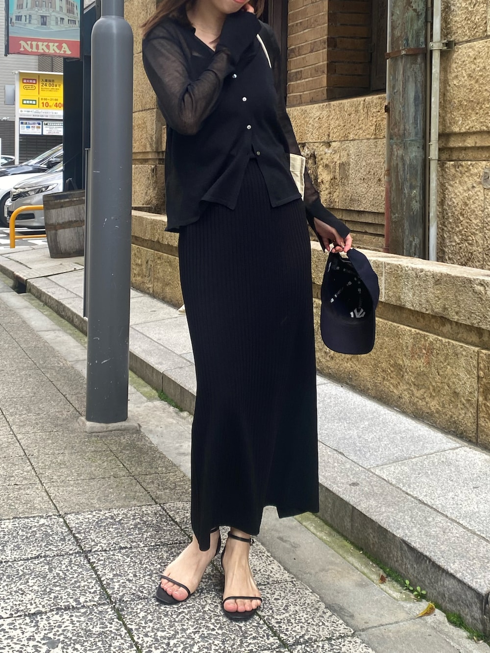 ブラック系のニット/セーター、ブラック系のスカートを着用したレディースの春コーディネートの3枚目の写真