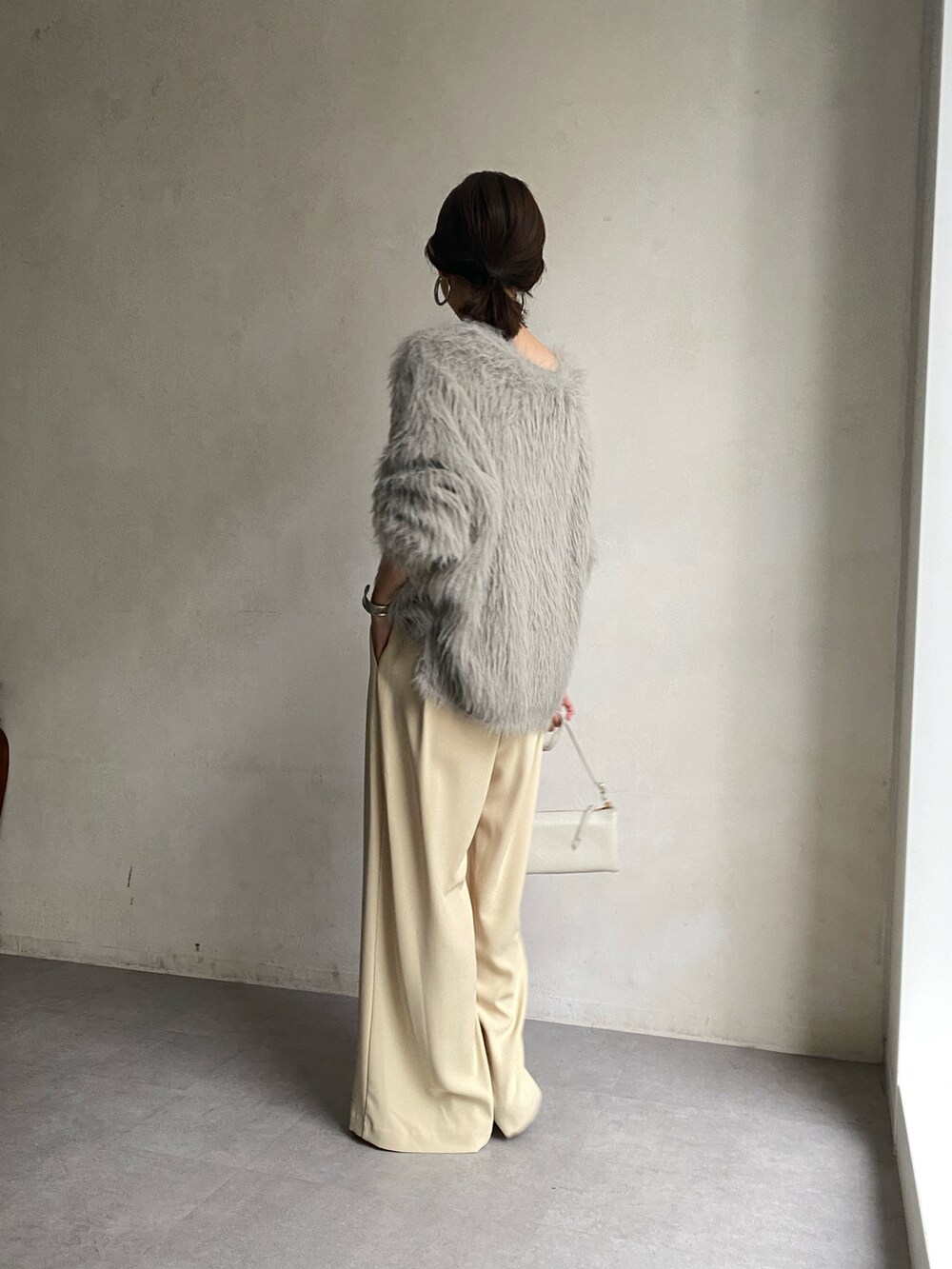 グレー系のニット/セーター、ベージュ系のショルダーバッグを着用したレディースの秋コーディネートの2枚目の写真