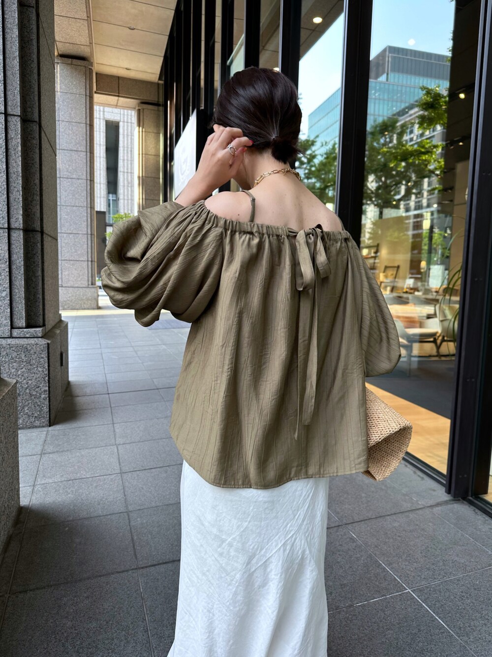 グリーン系のシャツ/ブラウス、ホワイト系のスカートを着用したレディースの春コーディネートの3枚目の写真