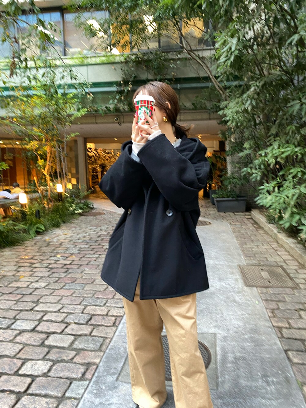 ブラック系のその他アウター、ベージュ系のチノパンツ、ホワイト系のTシャツ/カットソーを着用したレディースの秋コーディネートの4枚目の写真