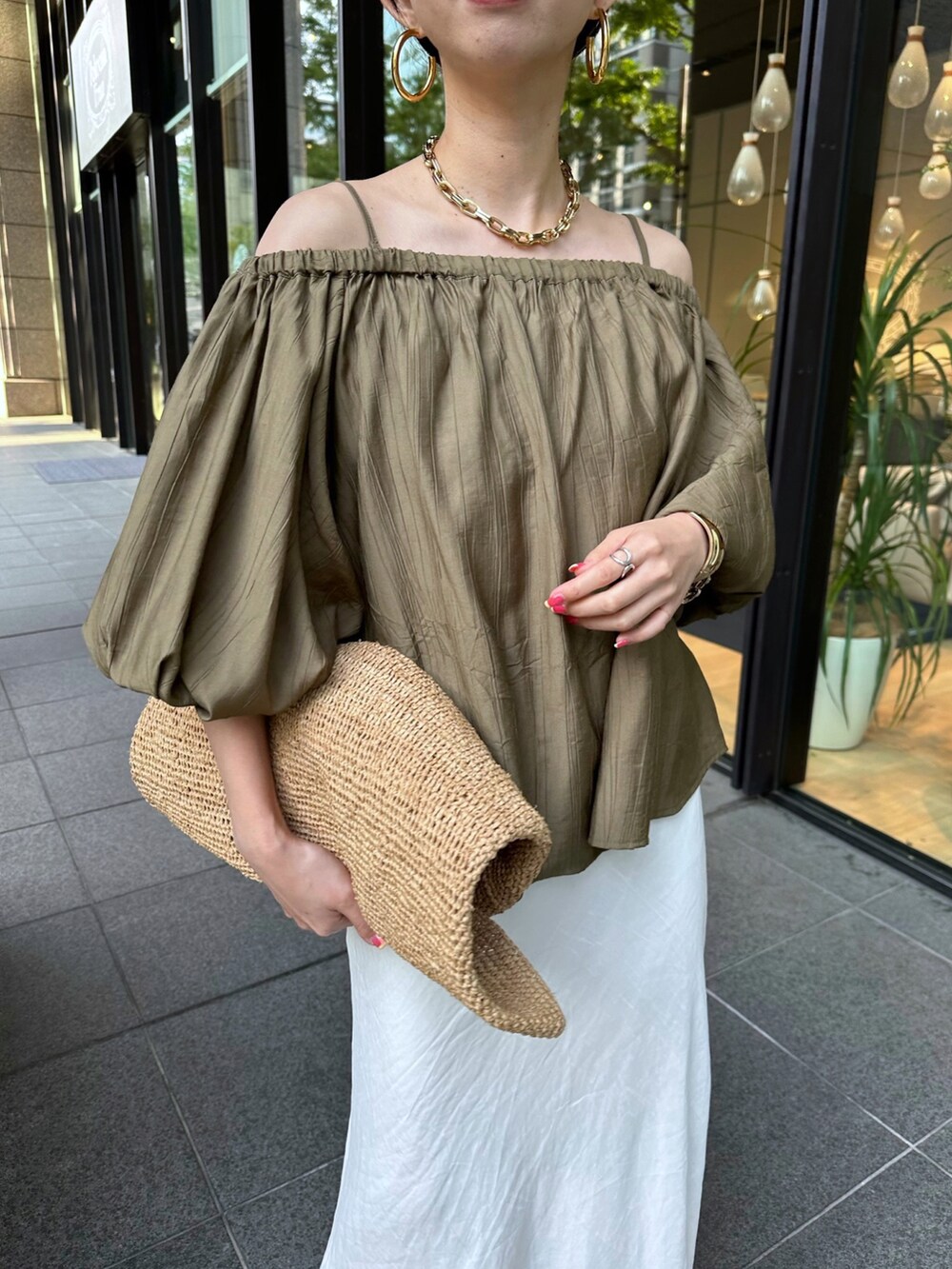 グリーン系のシャツ/ブラウス、ホワイト系のスカートを着用したレディースの春コーディネートの2枚目の写真